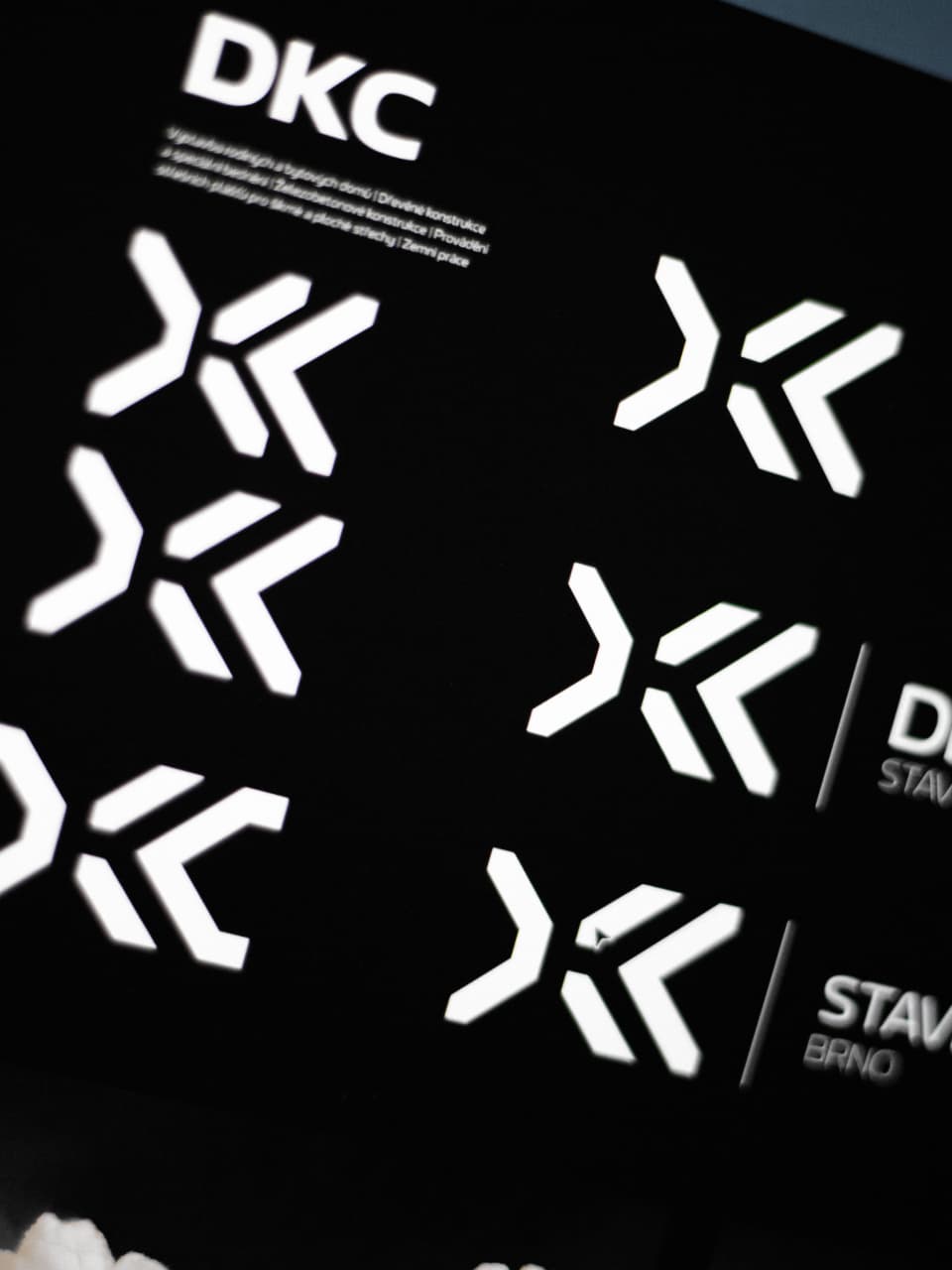 DKC logo pattern applied across a glossy black surface